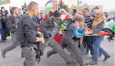  ?? NASSER NASSER/ASSOCIATED PRESS ?? Israeli border police officers scuffle with Palestinia­n protesters, some are dressed as Santa Claus, during a protest in front of an Israeli checkpoint, in the West Bank city of Bethlehem, Friday.