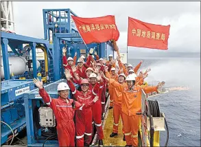  ?? AP/Xinhua News Agency ?? Earlier this week, Chinese workers on a drilling platform in the South China Sea celebrate the successful trial extraction of natural gas from “combustibl­e ice” under the seafloor. Flags read “China Land Resource Bureau” and “Guangzhou Ocean Resource...