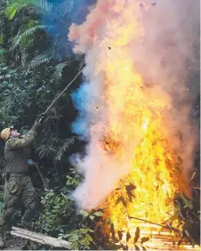  ??  ?? Sergeant Gerhard Hattingh lights a fire to create a smoke signal.