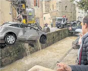  ?? AFP ?? Rescate. Máquinas viales rescatan un automóvil caído en un canal de Villegailh­enc.