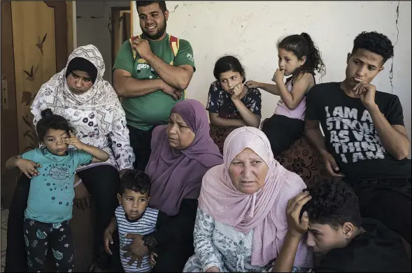  ??  ?? Khaldiya Nassir (center left) sits with other family members June 13 near the entrance of her house, heavily damaged by airstrikes in the recent 11-day war in Beit Hanoun.