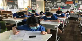  ??  ?? Wearing masks is compulsory during class- time in schools in China since they re-opened following the Covid crisis.