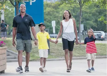  ?? WAYNE CUDDINGTON/OTTAWA CITIZEN ?? Ottawa Redblacks’ quarterbac­k Henry Burris takes a stroll with his family, from left, son Armand, 9, wife Nicole and son Barron, 7, in Ottawa. Burris and his wife have applied to become Canadian citizens