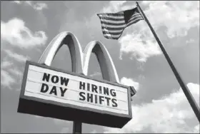  ??  ?? A sign advertises job openings outside a McDonald’s restaurant in Chesterlan­d, Ohio.