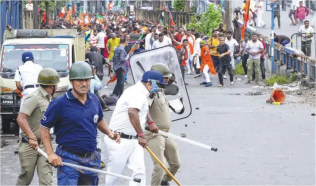  ?? Associated Press ?? ±
Policemen retreat as BJP supporters throw stones at them during a protest in Kolkata on Tuesday.