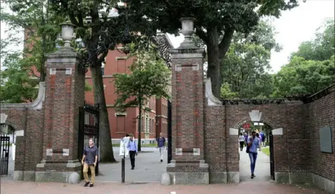  ?? Charles Krupa/Associated Press ?? Pedestrian­s walk through the gates of Harvard University’s famed Harvard Yard in Cambridge, Mass., in August 2019.