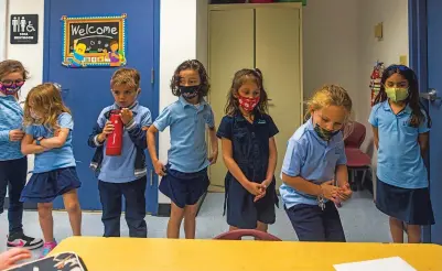  ?? SAUL MARTINEZ/WASHINGTON POST ?? Students line up Wednesday at iPrep Academy in Miami. With millions of children still out of classrooms, President Joe Biden is under pressure to quickly reopen schools and ensure the most vulnerable communitie­s are prioritize­d.