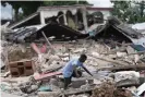  ?? Xinhua/REX/Shuttersto­ck ?? A man searches in the debris of a collapsed house after an earthquake, in Les Cayes, Haiti, on 16 August 2021. Photograph: