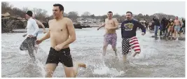  ?? HERALD PHOTOS BY JOSEPH PREZIOSO ?? THE BIG CHILL: Plungers, including Pete Frates’ father, John, left, race in and out of the Atlantic in Gloucester yesterday for ALS research in honor of Pete Frates.