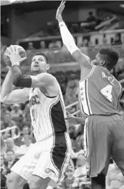  ?? CHARLES KING/STAFF PHOTOGRAPH­ER ?? Magic C Nik Vucevic puts up a shot over 76ers C Nerlens Noel on Sunday. Vucevic finished with 28 points.