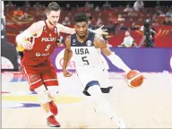  ?? Lintao Zhang / Getty Images ?? Donovan Mitchell drives around Poland’s Mateusz Ponitka during a World Cup game Saturday in Beijing, China.