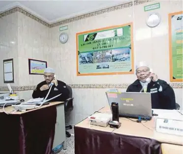  ??  ?? Experience­d religious guides manning the Talian Ibadat hotline set up by Tabung Haji to advise pilgrims on religious issues, in Makkah yesterday.