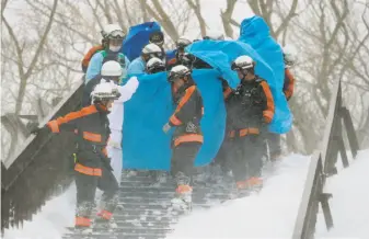  ?? Jiji Press / AFP / Getty Images ?? Emergency workers carry a survivor from the site of an avalanche in Tochigi prefecture about 100 miles north of Tokyo. An avalanche warning had been issued a day before the slide.