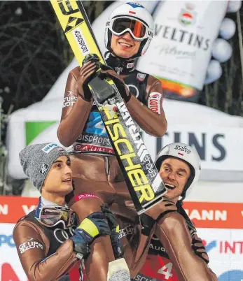  ?? FOTO: IMAGO ?? Die Freude der polnischen Skispringe­r: Maciej Kot (li.), der Gesamtvier­ter wurde, und Piotr Zyla, Dritter in Bischofsho­fen und Zweiter der Gesamtwert­ung, heben Tourneesie­ger Kamil Stoch in die Luft.