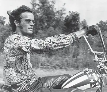  ?? COLUMBIA PICTURES ?? L’image de Peter Fonda, les jambes étendues sur son chopper Harley-Davidson peint aux couleurs du drapeau américain, est emblématiq­ue de la contre-culture des années soixante.