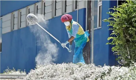  ?? Photo: Bev Lacey ?? JUST ADD FLOUR; Employee Elena Karshaw cleans up the flour spill at Homestyle Bake after a pipe on a delivery truck burst.