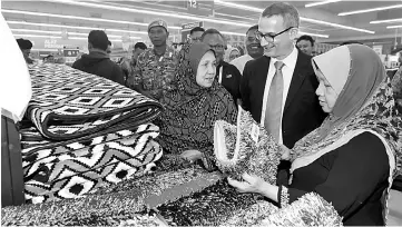  ??  ?? Pierre (middle) talks to customers perusing goods at the launch of Giant Tanjung yesterday. — Bernama photo