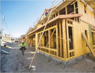  ?? JOHN GIBBINS U-T ?? Constructi­on work continues on single-family homes being built at the Seville at Escaya project in Chula Vista. The 135 new two-story homes start at $649,000.