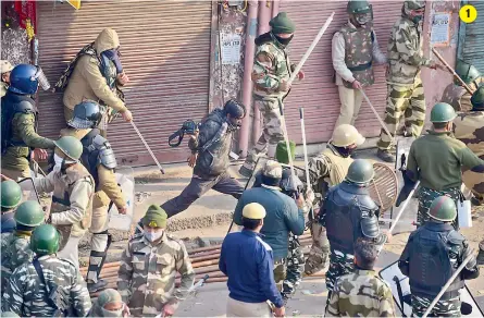  ??  ?? 1 1. Security personnel baton charge a protester during clashes after the farmers tractor rally turned violent on Republic Day in New Delhi on Tuesday.