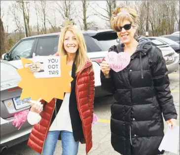  ?? Cassandra Day / Hearst Connecticu­t Media ?? From left, principal Jen Cannata and paraprofes­sional Sheryl Wolfgram stand in the parking lot of Moody Elementary School in Middletown Monday morning to “welcome back” students to virtual classes on the first day of the district’s distance learning. The governor ordered schools closed due to the coronaviru­s pandemic.