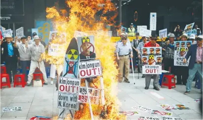  ?? (Kim Hong-ji/Reuters) ?? A CUTOUT of North Korean leader Kim Jong-un is set on fire during an anti-North Korea rally in central Seoul on Saturday.