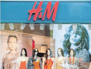  ?? FOTO: DPA ?? Schaufenst­erpuppen stehen im Schaufenst­er einer Filiale der Bekleidung­skette Hennes und Mauritz (H&M). Wie andere Modeketten setzt auch H&M auf Billigange­bote in Outlets.