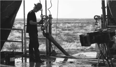  ??  ?? A 2014 photo shows a worker waiting to connect a drill bit on Endeavor Energy Resources’s Big Dog Drilling Rig 22 in the Permian basin outside of Midland, Texas. — WP-Bloomberg photo