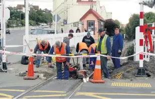  ?? PHOTO: DANIEL BIRCHFIELD ?? Men at work . . . Oamaru Steam and Rail Society volunteers work to prepare for the installati­on of sensors and concrete sleepers on the society’s track at the weekend.