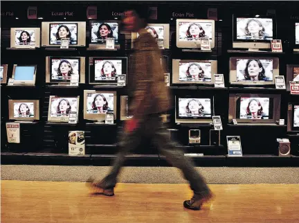  ?? FRED DUFOUR/AFP GETTY IMAGES FILES ?? A bank of TVs in Lyon, France, shows the news conference of French journalist Florence Aubenas in 2005, three days after her release from Baghdad following a five-month hostage ordeal. Their abduction sparked a campaign in France and Europe to have...