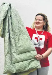  ?? PHOTO: PETER MCINTOSH ?? Warm welcome . . . Red Crossvolun­teer Hadil Catherina prepares bedding for new arrivals.