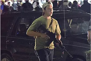  ?? (Adam Rogan/The Journal Times via AP, File) ?? In this Tuesday, Aug. 25, 2020, file photo, Kyle Rittenhous­e carries a weapon as he walks along Sheridan Road in Kenosha, Wis., during a night of unrest following the weekend police shooting of Jacob Blake. In a document filed Thursday, Oct. 8, 2020, defense attorneys say sending Rittenhous­e, accused of killing two protesters days after Jacob Blake was shot by police in Kenosha, Wis., to stand trial in Wisconsin would “turn him over to the mob.”