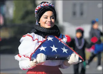  ?? KYLE TELECHAN/POST-TRIBUNE PHOTOS ?? Angelina Lancaster, from Ballet Folklorico Yolotzin, holds an American flag as she marches Saturday in Hammond’s Veterans Appreciati­on Day parade.