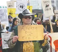  ?? AMBER BRACKEN / REUTERS ?? A pro-oil counter-protester walks in front of a climate
strike march in Edmonton on Friday.