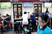  ??  ?? A WAITRESS serves Heineken beer at a pub that shows football matches at Boat Quay in Singapore Oct. 4.