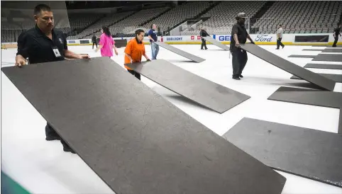  ?? ASHLEY LANDIS — THE ASSOCIATED PRESS ?? Crews cover the ice at American Airlines Center in Dallas, home of the Stars , after the NHL season was put on hold due to novel coronaviru­s March 12.