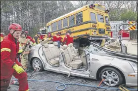  ??  ?? Cobb County firefighte­rs and rescuers “came together and were able to lift the school bus off the car, pull the car out and then cut the person out of the car,” Cobb fire battalion chief Chris Sobieski said.
