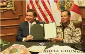  ?? Executive office of the governor ?? Gov. Ron DeSantis and Marcellus Osceola Jr., chairman of the Seminole Tribe, sign a gaming compact in the governor’s office at the Capitol in Tallahasse­e on April 23.