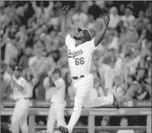  ?? The Associated Press ?? HOW THE WEST WAS WON: Dodgers outfielder Yasiel Puig celebrates his three-run home run during the seventh inning of a 5-2 win against the Colorado Rockies Wednesday in Los Angeles.