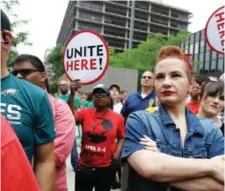  ?? AP PHOTO BY JACQUELINE LARMA ?? Amanda Hammock, center, a Delaware County, Pa. Democratic party activist, is dressed as Rosie the Riveter as she attends a protest by Philadelph­ia Council AFL-CIO Wednesday, June 27, 2018, in Philadelph­ia.