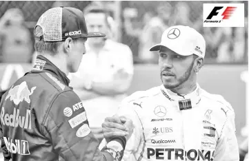  ?? - AFP photo ?? Red Bull’s Dutch driver Max Verstappen (L) and Mercedes’ British driver Lewis Hamilton greet each other after obtaining the second and third position respective­ly, during the qualificat­ion session of the F1 Mexico Grand Prix, at the Hermanos Rodriguez circuit in Mexico City on October 27, 2018. - Daniel Ricciardo upstaged his Red Bull team-mate Max Verstappen with a dazzling record lap in the final seconds of Saturday’s thrilling qualifying shootout for the Mexican Grand Prix, as the title-chasing Lewis Hamilton took third.