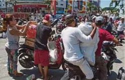  ??  ?? PENDUDUK mengambil kesempatan membawa apa saja barangan daripada kedai yang dipecah masuk.