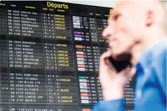  ?? (AP FOTO) ?? ALWAYS PLAN BEFORE YOU GO. A passenger makes a phone call as he walks by a flight informatio­n board at Brussels Airport in Belgium. You don’t have to pay a fortune to use your phone abroad, but you need to plan ahead.