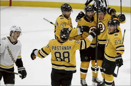  ?? Ap ?? Boston’s Brad Marchand (63) celebrates a goal by david Krejci, middle, with david pastrnak, patrice Bergeron (37) and Charlie Mcavoy, second from right, as pittsburgh’s John Marino skates by during the second period of Saturday’s game in Boston.