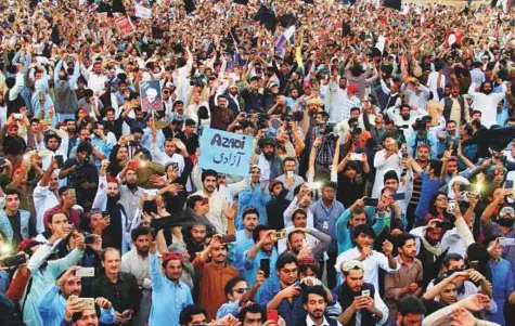  ?? Reuters ?? Members of the Pakistan’s Pashtun community, chant slogans and take photos of their leader Manzoor Pashteen during the Pashtun Tahaffuz Movement’s rally against, what they say, are human rights violations, in Lahore.