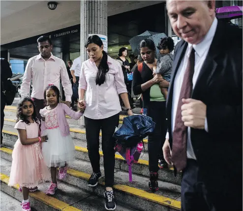  ?? ANTHONY WALLACE / AFP / GETTY IMAGES ?? Lawyer Robert Tibbo, right, with his clients who sheltered Edward Snowden while he was in Hong Kong. Tibbo says his clients are in danger of being deported to their native countries of Sri Lanka and the Philippine­s.