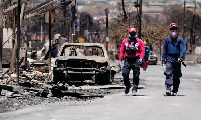  ?? Photograph: Rick Bowmer/AP ?? Members of a search-and-rescue team in Lahaina, Hawaii. The death toll is expected to rise after a fire swept through the historic town on Tuesday.