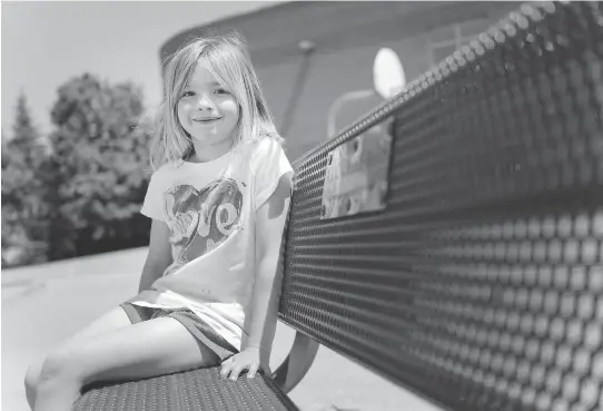  ?? DARREN BROWN ?? Ava Thorsell, 7, sits Tuesday on the “buddy bench” placed at A. Lorne Cassidy Elementary School in Stittsvill­e to honour Bryce Jude, who died of cancer in 2012. The school council asked Bryce’s mom, Dev Jude, about planting a memorial tree, but she suggested the buddy bench since she wanted something that reflected the boy’s vibrant personalit­y.