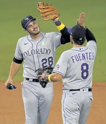  ?? Marcio Jose Sanchez, The Associated Press ?? Colorado‘s Nolan Arenado, left, celebrates with his cousin and teammate, Josh Fuentes, after the team’s 5-2 win over the Los Angeles Dodgers on Saturday night.