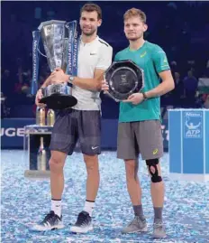  ?? — Reuters ?? Bulgaria’s Grigor Dimitrov celebrates with the trophy after winning the final and runner up Belgium’s David Goffin.