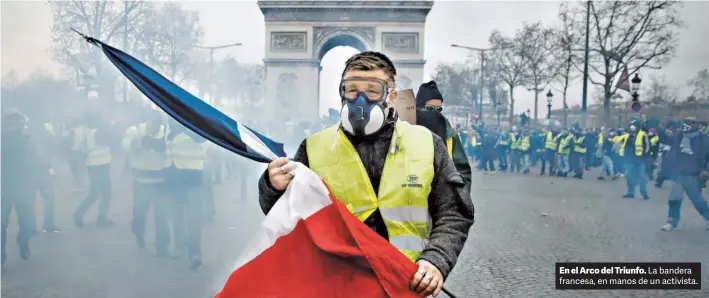  ?? REUTERS ?? En el Arco del Triunfo. La bandera francesa, en manos de un activista.